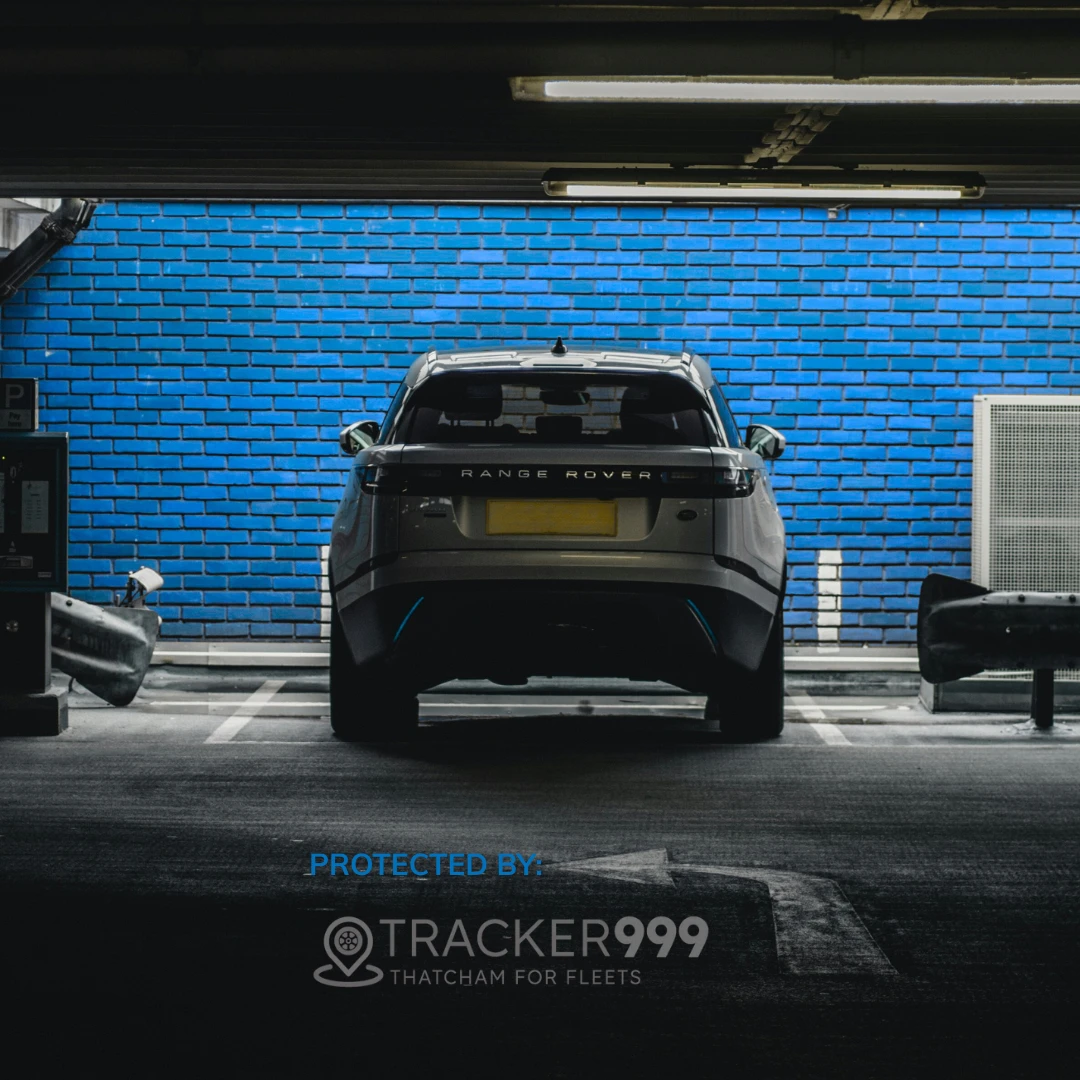 Rear view of Range Rover parked in a garage with Tracker999 branding and blue wall